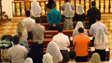 Católicos tradicionalistas rezando en misa tridentina