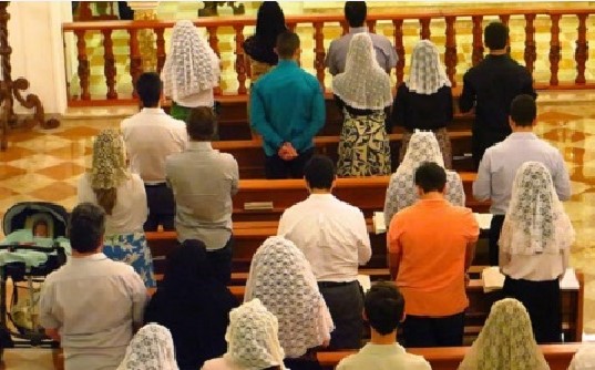 Católicos tradicionalistas rezando en misa tridentina