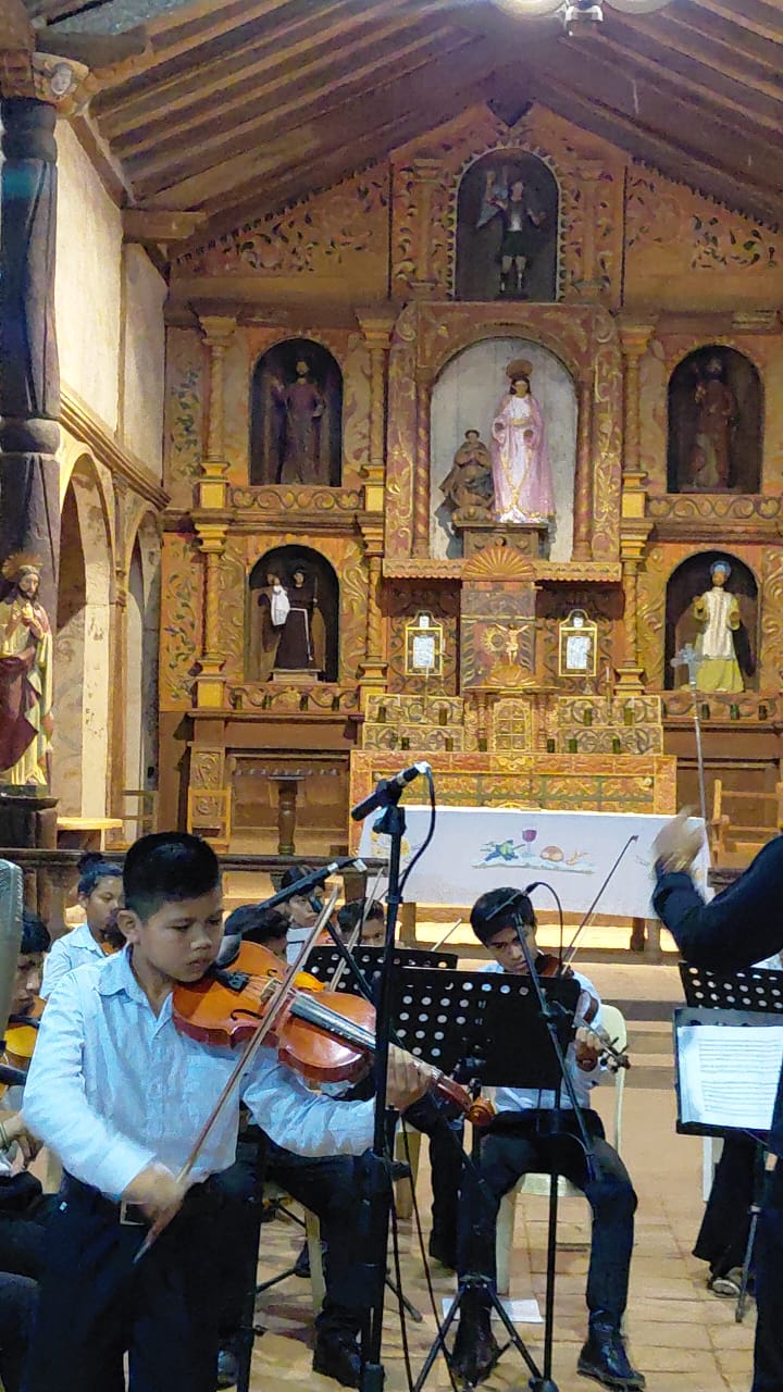 Niños tocando sus instrumentos dentro de una iglesia en Santa Ana de Velasco durante el festival de música barroca de 2025.