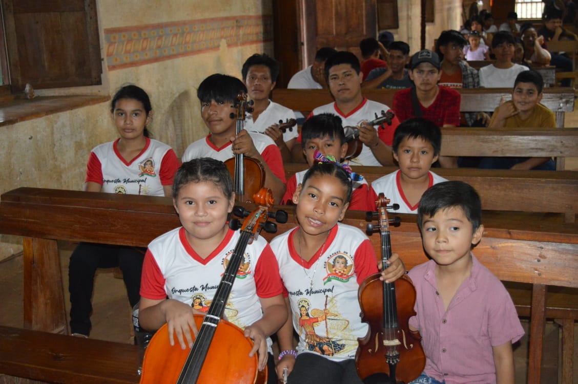 Niños que tocan en una orquesta municipal, sentados en una iglesia en Santa Ana de Velasco durante el festival de música barroca de 2025.