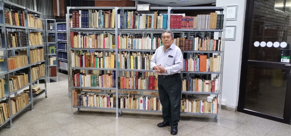 Daniel Pasquier Rivero, PhD, posa junto a la biblioteca. Foto: Aarón Mariscal.
